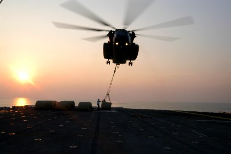 US Navy 050903-N-8154G-253 A U.S. Navy MH-53E Sea Dragon helicopter lifts two 500-gallon bladders full of fresh drinking water for transport from the flight deck of the amphibious assault ship USS Bataan (LHD 5)