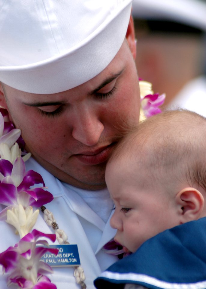 US Navy 050908-N-3019M-006 Seaman Chad Herod, assigned to the guided missile destroyer USS Paul Hamilton (DDG 60), holds his son after returning to Pearl Harbor