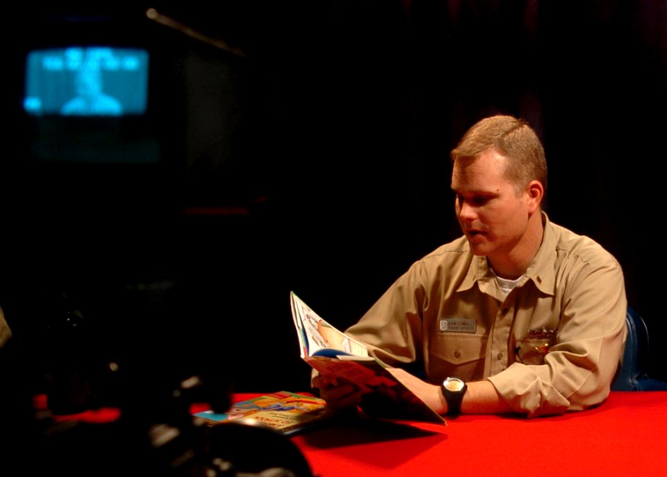 US Navy 050918-N-0716S-004 Ens. John Connally, the communications officer aboard the amphibious assault ship USS Tarawa (LHA 1), records himself reading for his daughter and wife back home in San Diego, through a program called