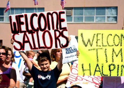 US Navy 050908-N-0653J-002 A family member holds-up a welcome home sign as he welcomes home his cousin who is assigned to the Los Angeles-class attack submarine USS Augusta (SSN 710)