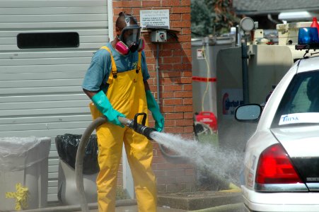US Navy 050919-N-9274T-002 Shawn Thomas of the New York Fire Department, uses a fire hose to clean tires of a police car with bleach and chlorine at a decontamination station