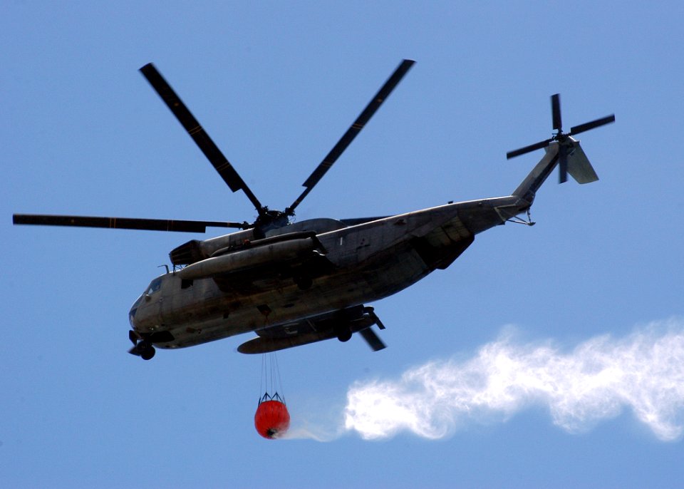 US Navy 050816-N-3019M-002 A U.S. Marine Corps CH-53E Super Stallion helicopter prepares to drop more than 2,000 gallons of water on a brushfire on the island of Oahu, Hawaii