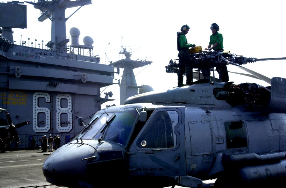 US Navy 050922-N-0361G-027 Aviation Electrician's Mate 2nd Class Jason Russell and Aviation Electrician's Mate 3rd Class Luke Rimando adjusts the blade fold switches on an SH-60F Seahawk helicopter