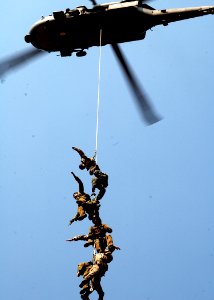 US Navy 050819-N-0716S-013 Members of the U.S. Navy Explosive Ordnance Disposal Mobile Unit Three (EODMU-3), Detachment 7, and Australia's Clearance Dive Team hang from a Suspended Personnel Insertion Extraction (SPIE) ri photo