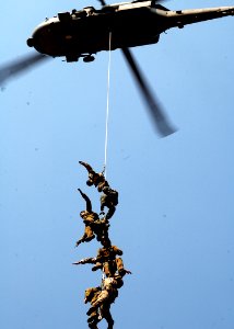 US Navy 050819-N-0716S-013 Members of the U.S. Navy Explosive Ordnance Disposal Mobile Unit Three (EODMU-3), Detachment 7, and Australia's Clearance Dive Team hang from a Suspended Personnel Insertion Extraction (SPIE) ri