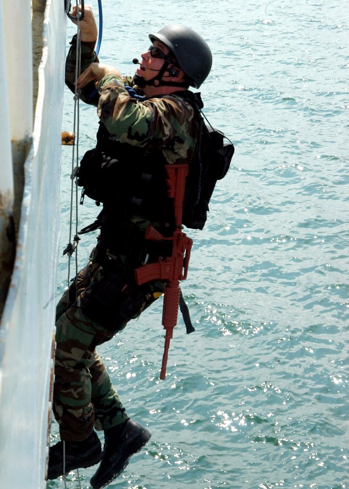 US Navy 050923-N-3019M-003 A Sailor assigned to the guided missile cruiser USS Cowpens (CG 63), climbs a ladder to board the ex-U.S. Coast Guard Cutter Yacona as part of a visit, board, search and seizure (VBSS) exercise