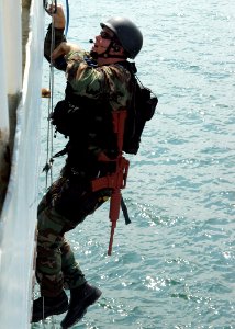 US Navy 050923-N-3019M-003 A Sailor assigned to the guided missile cruiser USS Cowpens (CG 63), climbs a ladder to board the ex-U.S. Coast Guard Cutter Yacona as part of a visit, board, search and seizure (VBSS) exercise