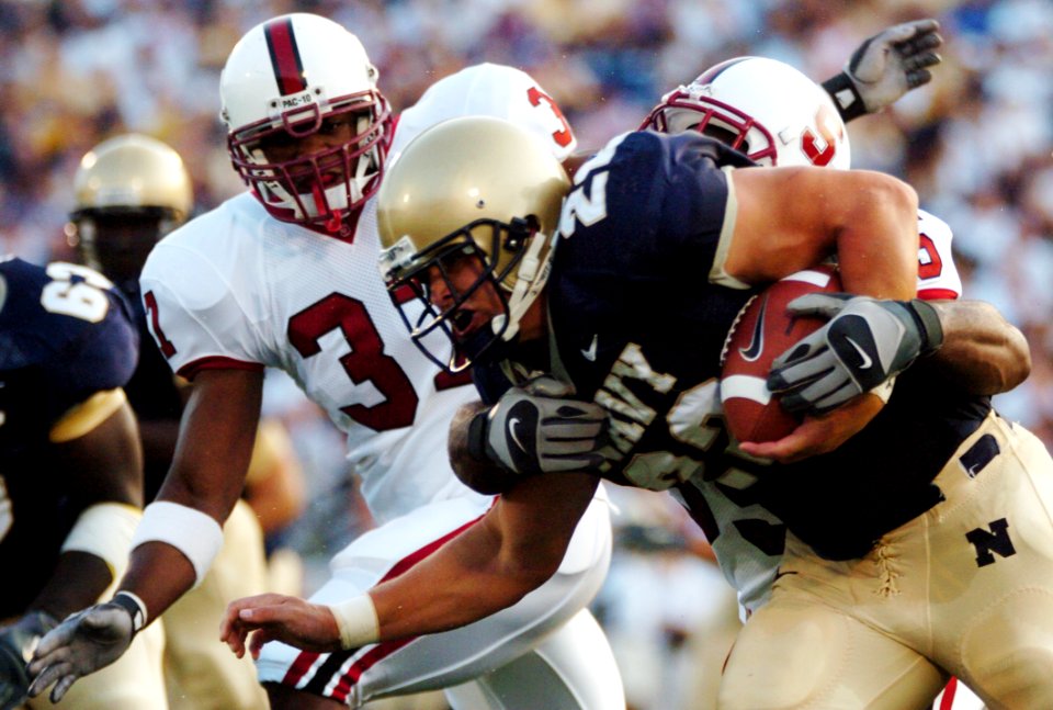 US Navy 050910-N-9693M-002 U.S. Naval Academy Midshipmen fullback Adam Ballard is tackled by Stanford Cardinal linebacker Michael Okwo