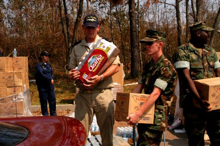 US Navy 050912-N-0793G-004 U.S. Navy Seabees stationed in Gulfport, Miss., help load food and water into cars with the help of Dutch and Mexican Sailors