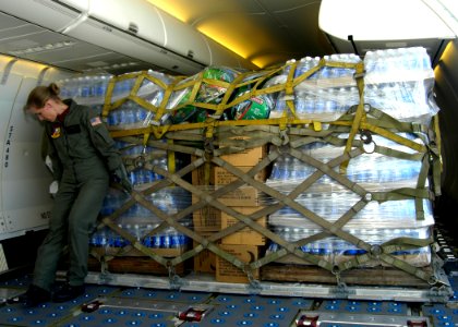 US Navy 050903-N-9500T-019 U.S. Navy Aviation Warfare Systems Operator 1st class Amy Skillings, a load master trainee assigned to Fleet Logistics Squadron Five Seven (VR-57), pushes into place, a pallet of relief supplies for t