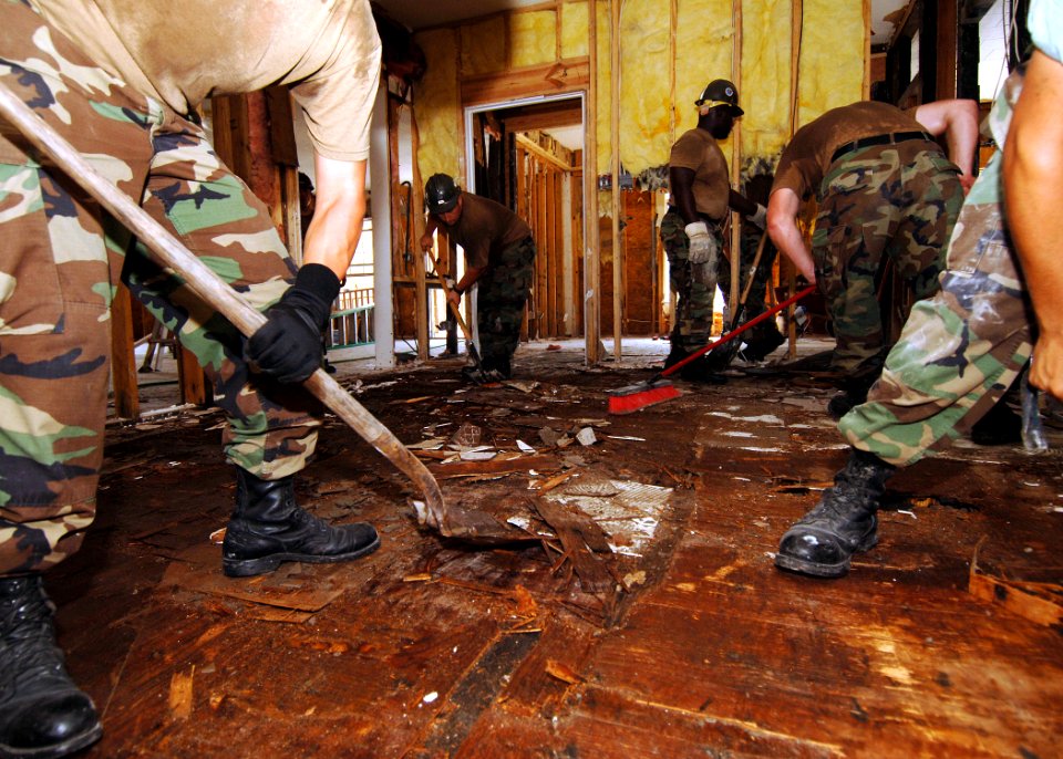 US Navy 050912-N-4374S-005 U.S. Navy Seabees, assigned to Naval Mobile Construction Battalion One Three Three (NMCB-133), tear through a plywood floor as they take part in restoring Hope Haven