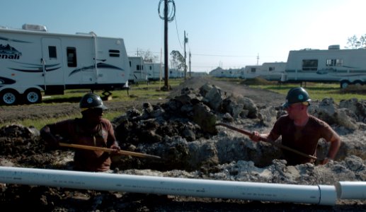 US Navy 050928-N-2653P-067 Utilitiesman Gregory Knight and Hospital Corpsman 1st Class Joshua Ross assigned to Naval Mobile Construction Battalion Four Zero (NMCB-40), dig trenches for sewage lines