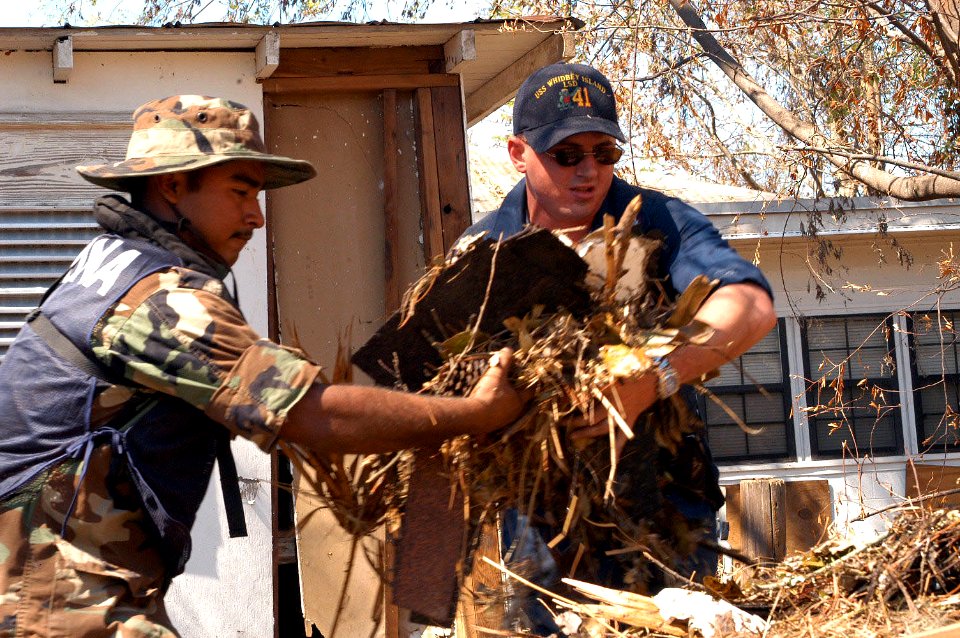 US Navy 050911-N-0793G-006 A U.S. Navy Sailor, assigned to the dock landing ship USS Whidbey Island (LSD 41), and a Mexican Navy Sailor work together to clear debris from a house in a neighborhood in Biloxi, Miss