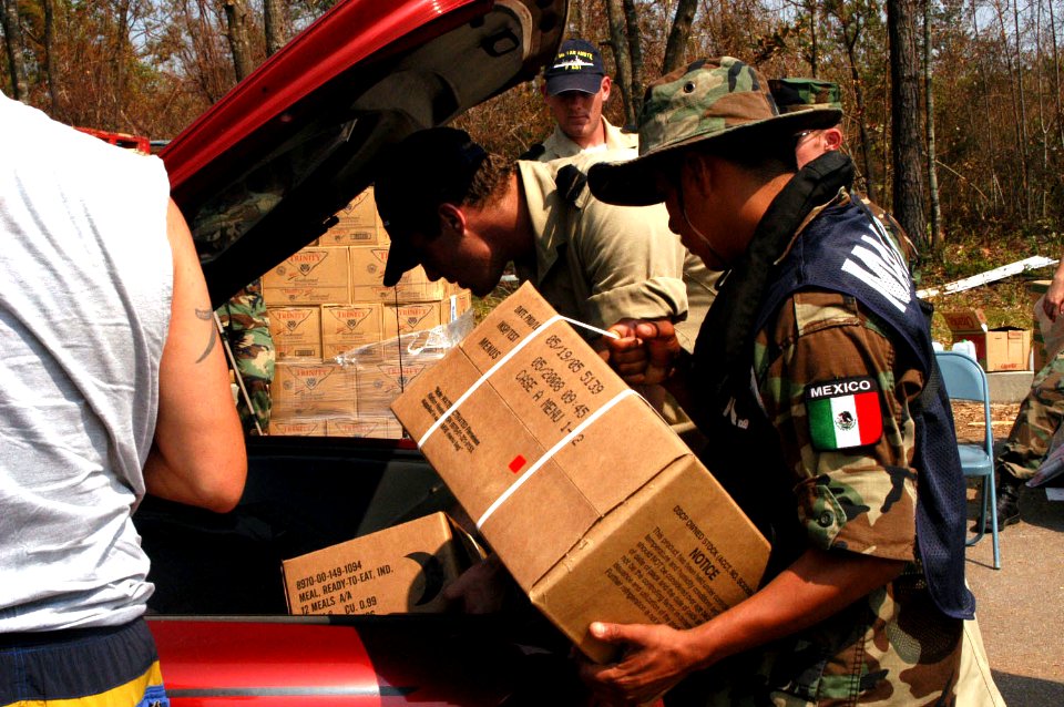 US Navy 050912-N-0793G-005 U.S. Navy Seabees, Mexican Marines and Dutch Sailors load food and water in a car at a Red Cross distribution point in Gulfport, Miss