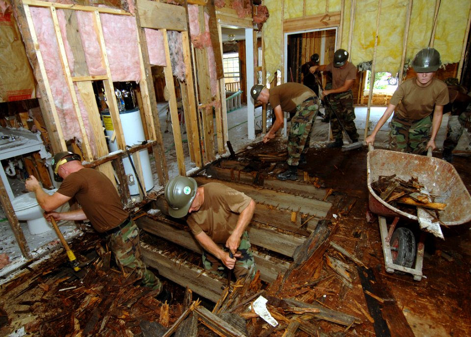 US Navy 050912-N-4374S-013 U.S. Navy Seabees, assigned to Naval Mobile Construction Battalion One Three Three (NMCB-133), tear through a plywood floor as they take part in restoring Hope Haven