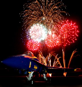 US Navy 050931-N-9769P-001 Fireworks explode and highlight an F-A-18A Hornet, assigned to the U.S. Navy flight demonstration team, the Blue Angels, at the Mid-South Air Show at the Millington Municipal Airport photo