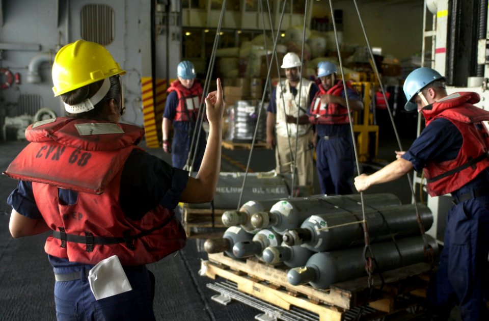 US Navy 050919-N-0361G-165 Boatswain's Mate 3rd Class Esther Gil, left, directs off-loading of cargo during a connected replenishment