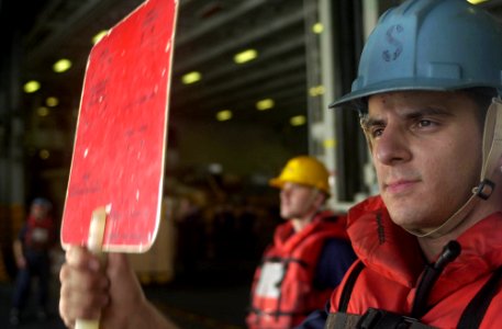 US Navy 050919-N-0361G-053 Seaman Justin Dodds flashes the hold signal board during a replenishment at sea