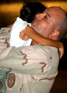 US Navy 050915-N-3019M-003 Master-at-Arms 1st Class Robert Blais, assigned to Naval Station Pearl Harbor Security, hugs his daughter after returning from an eight-month deployment