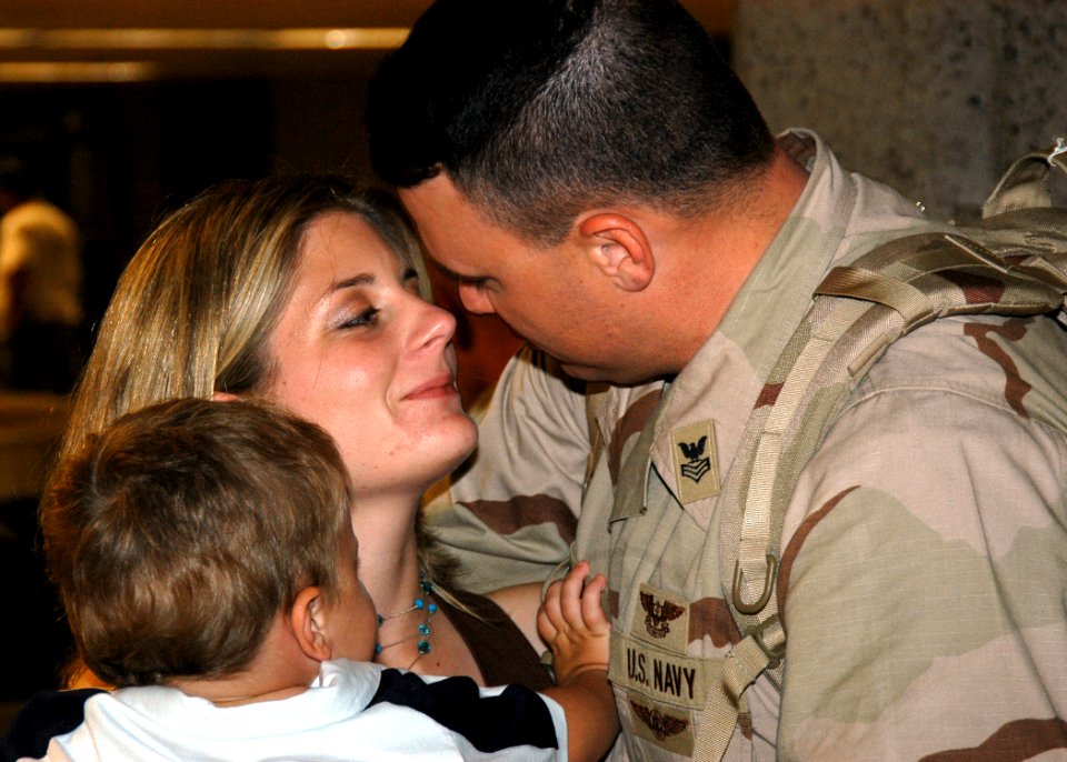 US Navy 050915-N-3019M-002 Master-at-Arms 1st Class Joshua Johnson, assigned to Naval Station Pearl Harbor Security, greets his wife and son after returning from an eight-month deployment