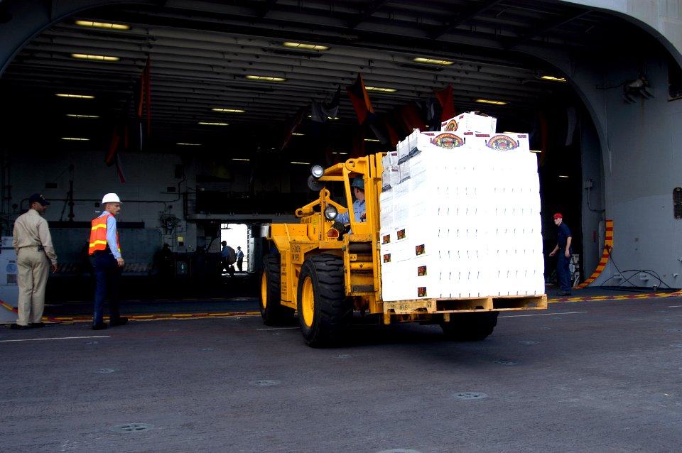 US Navy 050920-N-1467R-017 Sailors assigned to the amphibious assault ship USS Bataan (LHD 5) move a pallet of supplies into the hangar bay