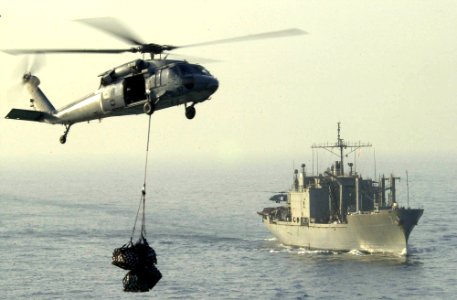 US Navy 050912-N-0361G-043 An MH-60S Seahawk helicopter carries cargo from the Military Sealift Command (MSC) combat stores ship USNS San Jose (T-AFS 7)