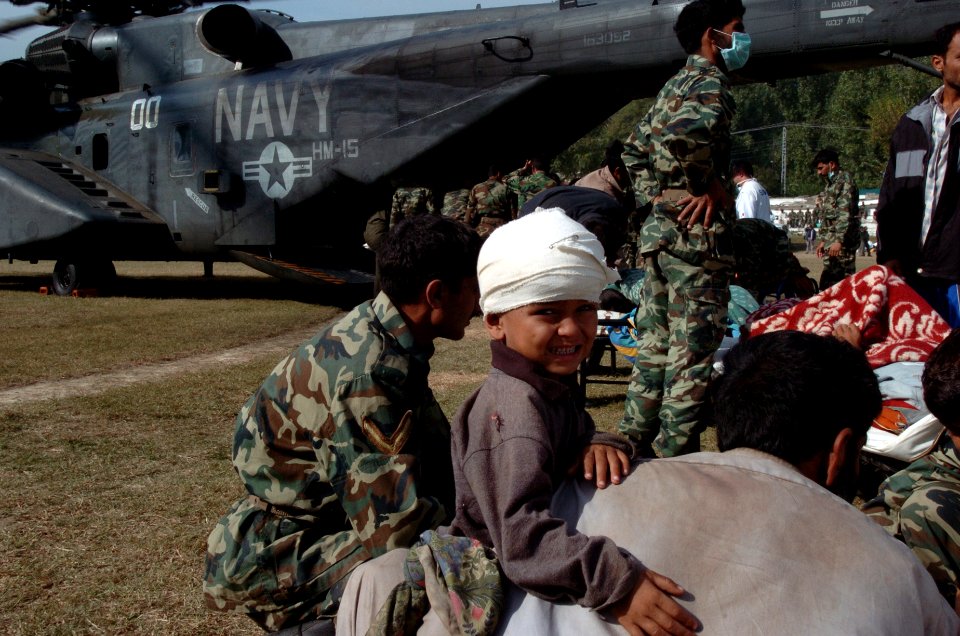 US Navy 051014-N-8796S-154 An injured Pakistani boy is carried by his father to a U.S. Navy MH-53E Sea Stallion helicopter where he will be transported to the city of Chaklala, Pakistan for medical treatment