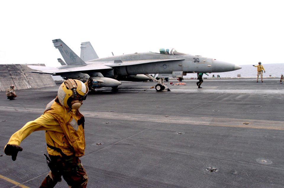 US Navy 050926-N-0413R-013 Aviation Boatswain Mate Airman Danielle Maniscalo from San Antonio, Texas, directs an F-A-18C Hornet assigned to the Red Devils of Marine Fighter Attack Squadron Two Three Two (VMFA-232)