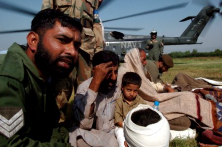 US Navy 051014-N-8796S-222 Pakistani Soldiers comfort injured civilians as they are moved to medical treatment from a U.S. Navy MH-53E Sea Stallion helicopter