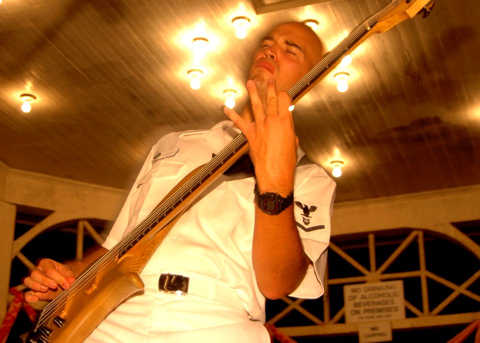 US Navy 050924-N-3019M-001 Musician 3rd Class James Randorff, assigned to the Pacific Fleet Rock Band in Pearl Harbor, plays the bass during a concert