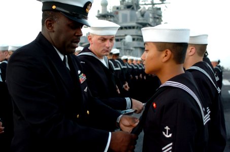 US Navy 051003-N-9866B-004 Chief Boatswain's Mate Keith Oliver, left, evaluates his Sailors during a Service Dress Blues uniform inspection