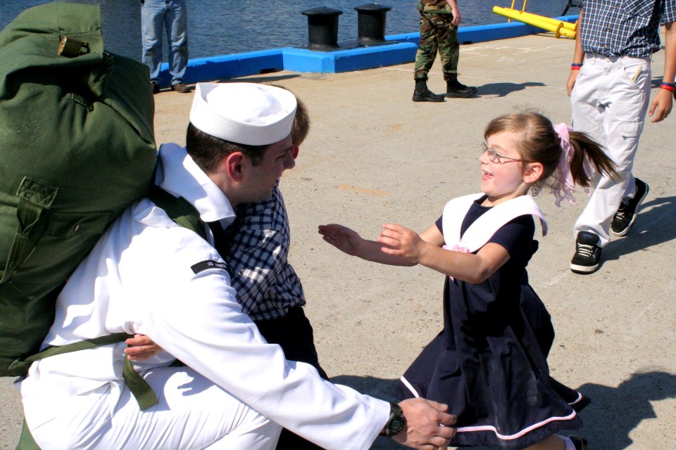 US Navy 050908-N-0653J-004 A Sailor assigned to the Los Angeles-class attack submarine USS Augusta (SSN 710) welcomes family members on the pier after returning home from deployment