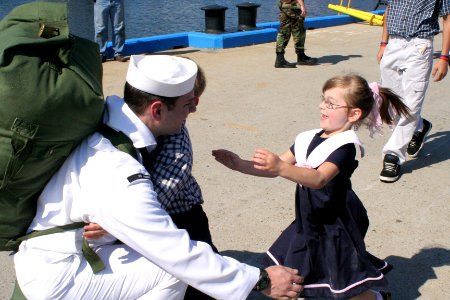 US Navy 050908-N-0653J-004 A Sailor assigned to the Los Angeles-class attack submarine USS Augusta (SSN 710) welcomes family members on the pier after returning home from deployment