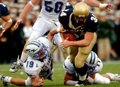 US Navy 051008-N-9693M-015 U.S. Naval Academy Midshipman full back Matt Hall is pulled down by Air Force free safety Ty Paffett (19) and free safety Bobby Giannini (11) during the 2nd quarter of play against the Falcons