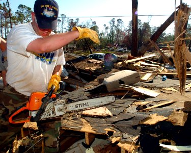US Navy 051019-N-3729H-257 U.S. Navy Draftsman 2nd Class Robert Smith, assigned to the Nimitz-class aircraft carrier USS John C. Stennis (CVN 74), prepares to cut into a destroyed house with a chainsaw