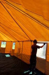 US Navy 050928-N-2653P-035 Construction Electrician Tom Lucy assigned Naval Mobile Construction Battalion Four Zero (NMCB-40) helps assemble a tent, which is part of a larger 500 person Federal Emergency management Agency (FEMA