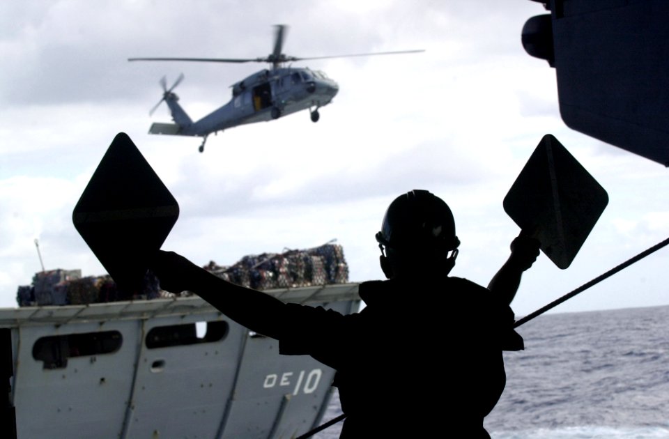 US Navy 051005-N-0361G-079 Seaman Justin Dodds of Pittsburgh, Pa., uses a sign to signal, advance the line to the Military Sealift Command (MSC) fast combat support ship USNS Bridge (T-AOE 10) during replenishment