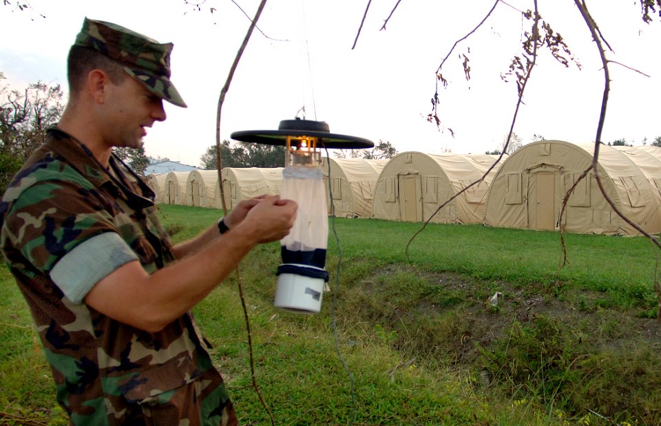 US Navy 050910-N-2653P-132 Forward Deployable Preventive Medicine Unit (FDPMU) East, removes a Light Trap provided by the Centers for Disease Control (CDC) from a tent city area on board NAS JRB New Orleans