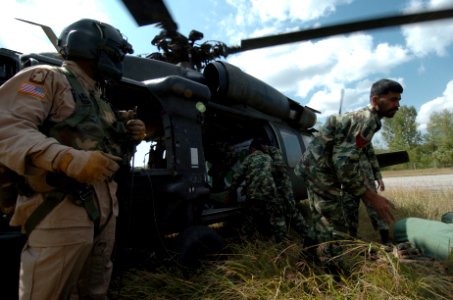 US Navy 051012-N-8796S-071 A U.S. Army aircrew member oversees the unloading of a UH-60 Blackhawk helicopter as members of the Pakistan military stack tents and other emergency aid in the remote Pakistani village of Rawalakot