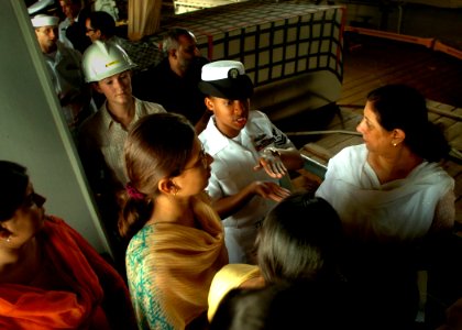 US Navy 051024-N-0716S-011 U.S. Navy Operations Specialist 2nd Class Tomika Harris explains well deck operations to a group of young Pakistanis during a tour of the dock landing ship USS Pearl Harbor (LSD 52) in Karachi, Pakist