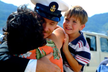 US Navy 051016-N-4772B-037 Chief Hull Technician Clifford Morin embraces his wife and son as the rescue and salvage ship USS Safeguard (ARS 50) returns to Sasebo, Japan