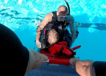 US Navy 051005-N-3019M-007 Boatswain's Mate 2nd Class Michael Santiago, assigned to the guided missile destroyer USS Paul Hamilton (DDG 60), prepares to lift a victim out of the water during a search and rescue swimmer dr