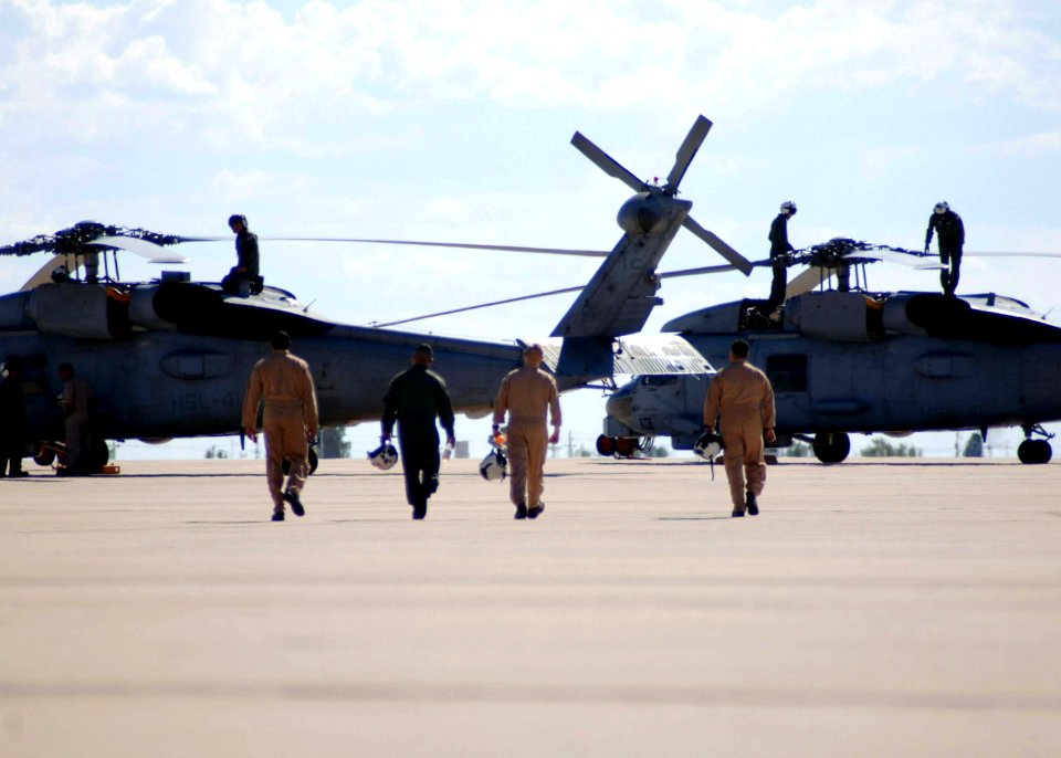US Navy 051007-F-8769P-004 U.S. Navy flight crews walk toward their SH-60B Seahawk helicopters as air crewmen perform pre-flight checks