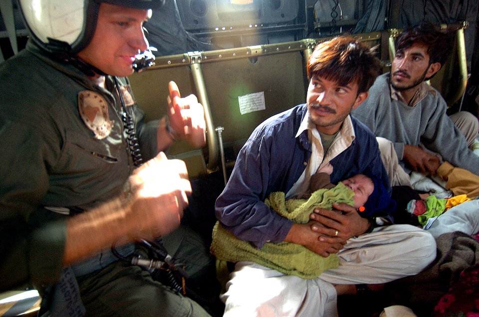 US Navy 051014-N-8796S-172 U.S. Navy Aviation Electronics Technician 2nd class John Wilkins speaks with injured Pakistanis aboard a MH-53E Sea Dragon helicopter