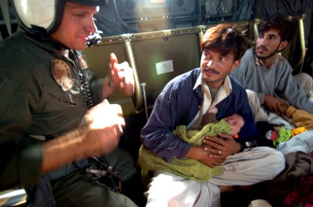 US Navy 051014-N-8796S-172 U.S. Navy Aviation Electronics Technician 2nd class John Wilkins speaks with injured Pakistanis aboard a MH-53E Sea Dragon helicopter