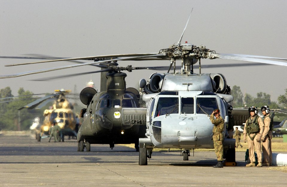 US Navy 051019-F-9085B-013 A U.S. Navy SH-60 Sea Hawk helicopter flight crew waits in line in front of a U.S. Army CH-47 Chinook and a Pakistani Mi-17 helicopter