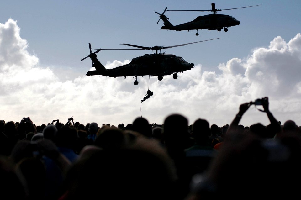 US Navy 051104-N-8158F-125 Crew members, friends and family watch as an HH-60H and an SH-60F Seahawk helicopter demonstrate search and rescue techniques during an airpower demonstration