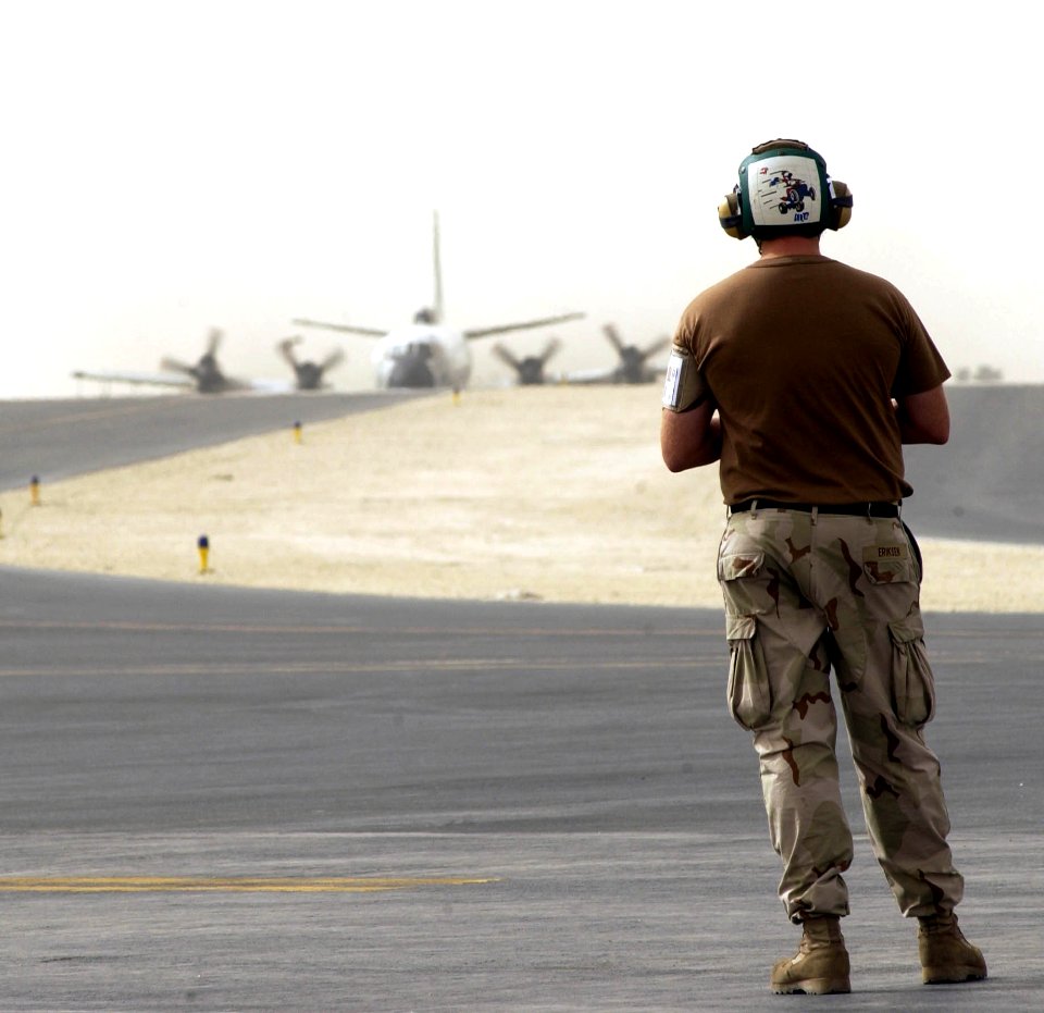 US Navy 050925-F-0375W-006 U.S. Navy Aviation Structural Mechanic 1st Class Greg Eriksen, assigned to Commander Task Group 57.1, waits for an EP-3E Aries aircraft to taxi after a flight from Bahrain