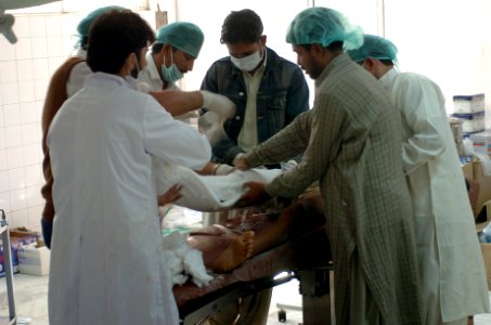 US Navy 051013-N-8796S-208 Pakistani doctors operate on an injured woman at one of the only hospitals left operational in the city of Muzafarabad, Pakistan photo
