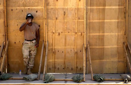 US Navy 051108-F-7234P-068 While taking a break in the shade, U.S. Navy Petty Officer 3rd Class Terence Ruben, assigned to Naval Mobile Construction Battalion Three (NMCB-3), takes a drink of juice